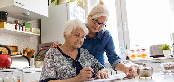 Kachelbild: Frau unterstützt Rentnerin in Küche