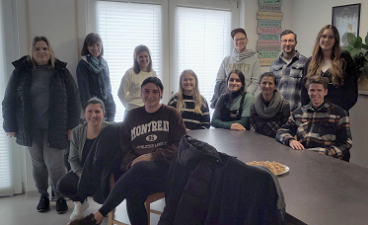 Die Schüler:innen stehen hinter einem Tisch zu einem Gruppenfoto nebeneinander.