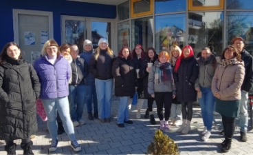 Die Gruppe aus Schüler:innen und Lehrerinnen steht vor dem Neue-Welt-Kino Weiden für ein Gruppenfoto nebeneinander