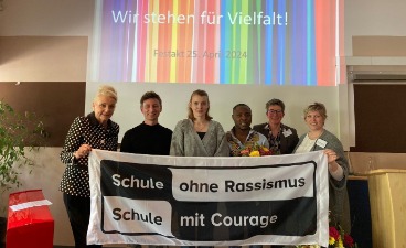 Titelverleihung Schule ohne Rassismus - Fahne mit Personen