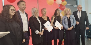 Abschlussfeier 2023 Ein Gruppenfoto bestehend aus zwei Männern und fünf Frauen. Zwei Frauen halten ein Zeugnis in der Hand.